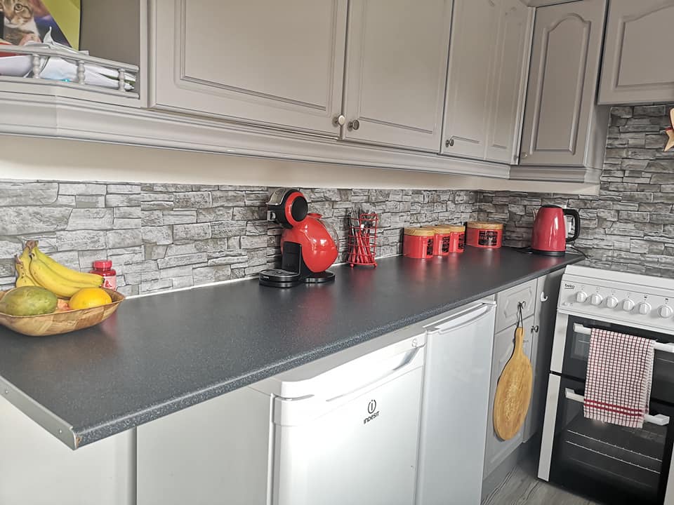  She massively improved the cabinets by painting them a modern grey colour, replacing the faded white from before