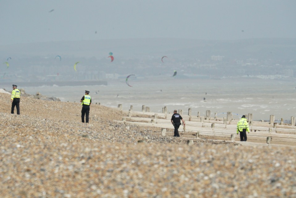  Cops patrol the beach near Worthing Pier after a mysterious suspected chemical spill