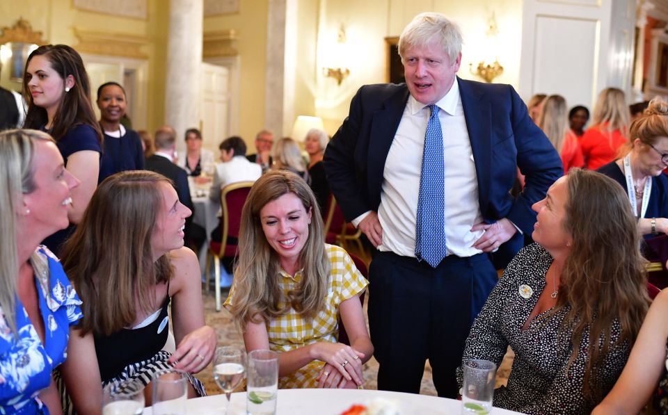  The PM, 55, and his partner, 31, were snapped chatting to guests at a No10 reception for hospice workers