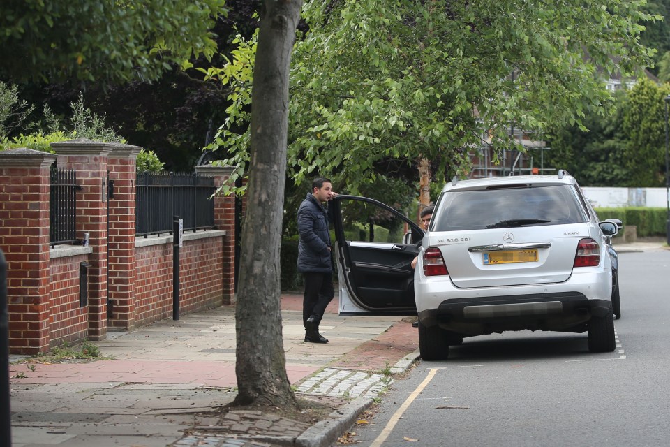 A guard on the street checks around Ozil's house