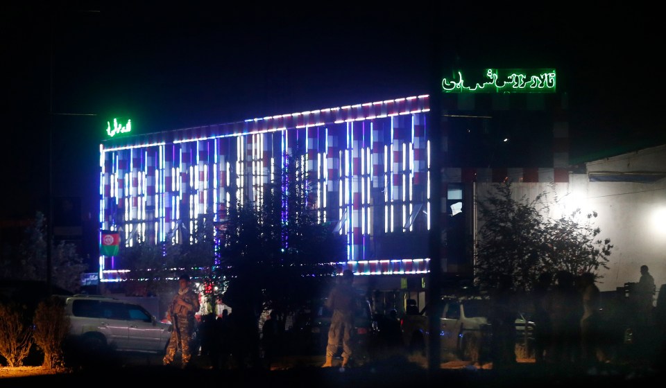 Afghan police men stand guard outside the wedding hall after an explosion in Kabul