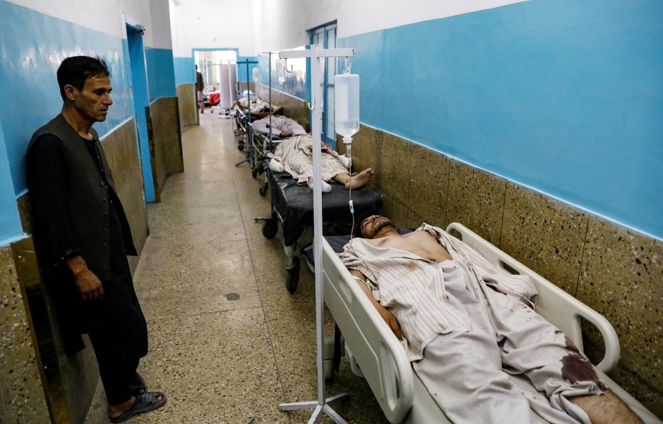 Wounded victims line a hospital hallway after the suicide bomb attack in Kabul on Saturday night