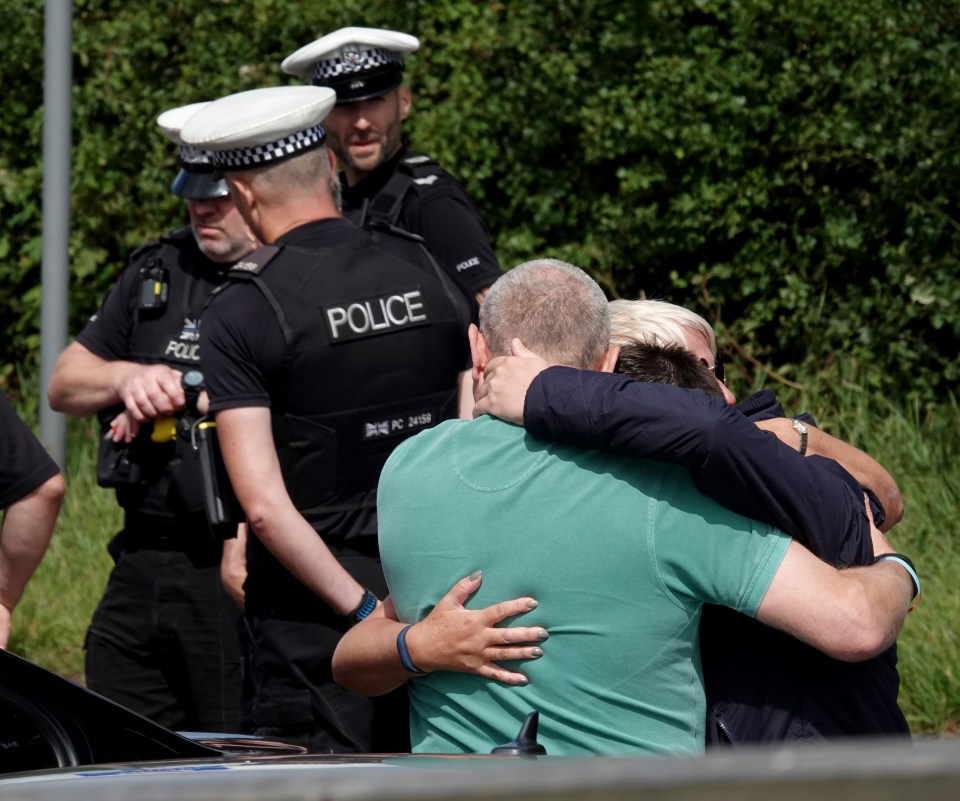 Grieving mourners console each other as they pay tribute to PC Harper today