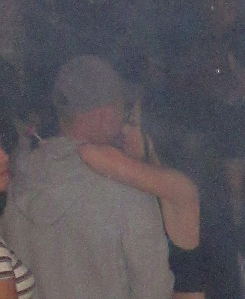 A brunette was seen with her arm draped across the star at the nightclub