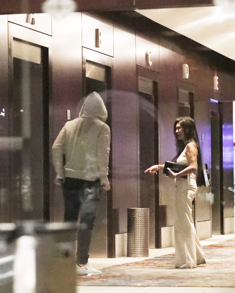 Rooney is pictured with a mystery woman by the lifts in his team’s Vancouver hotel