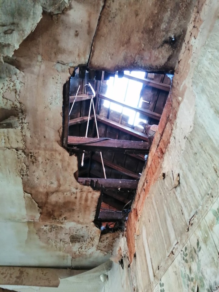  In one room, the ceiling has fallen through and you can see right through to the attic and the hole in the roof