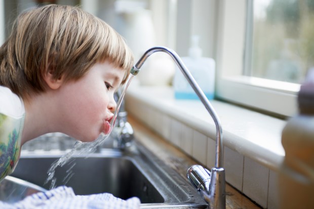 Child drinking water out the tap