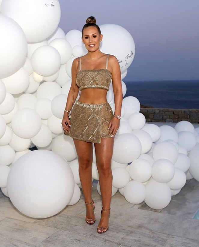  Kate wears the Revolve suit in front of a balloon wall at the Mykonos villa