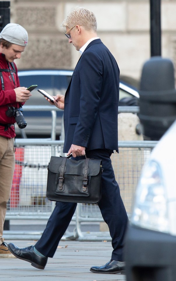  Jo Johnson checks his phone as he walks through Westminster this morning