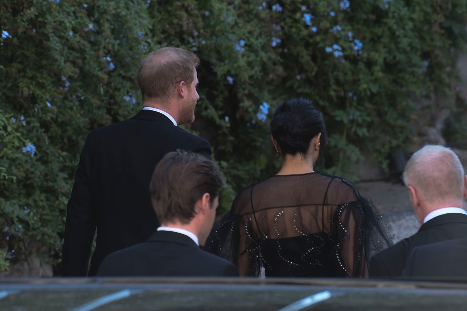 Meghan’s dress had sheer, voluminous sleeves and a black bodice