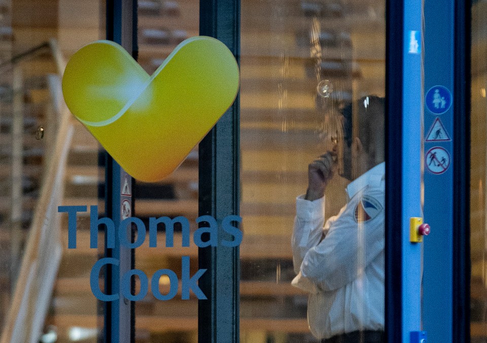 A security person stands next to the entrance of the German headquarters of travel company Thomas Cook in Oberursel near Frankfurt