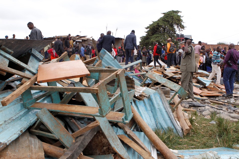  A police officer stands near the debris after the school suddenly collapsed