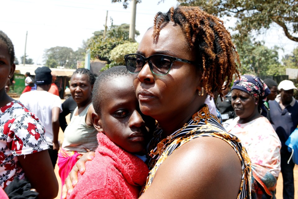  A woman comforts a child whose sister died