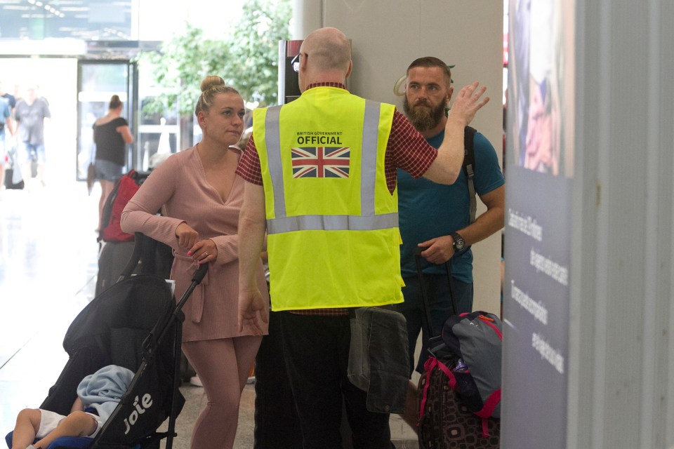 A British government official talks to British passengers at Palma de Mallorca airport