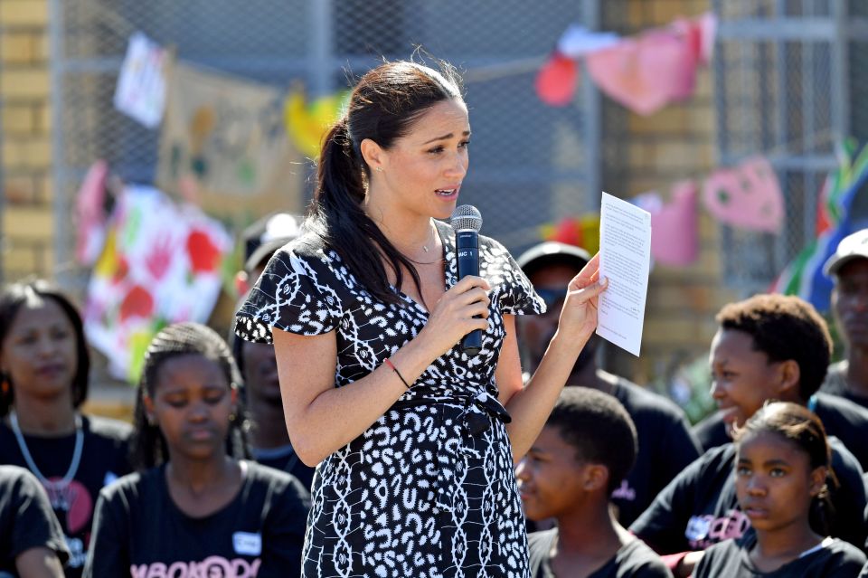  The Duchess of Sussex stands on a tree stump to speak to the crowd