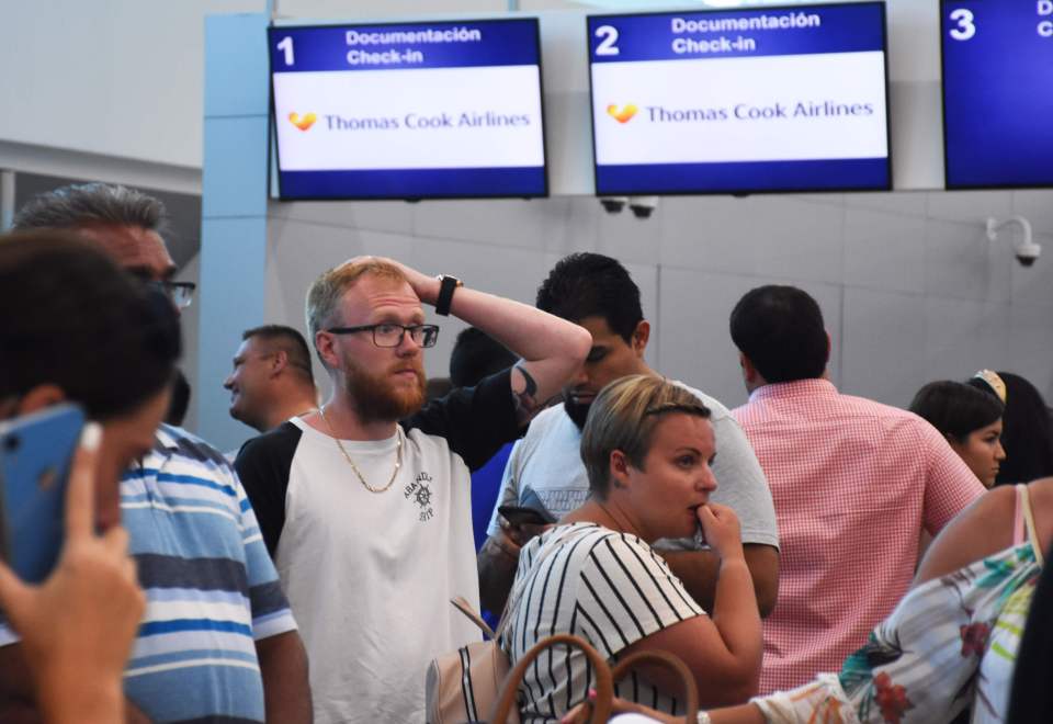 One passenger looks exasperated as he waits for information at the Thomas Cook check-in desk in Cancun