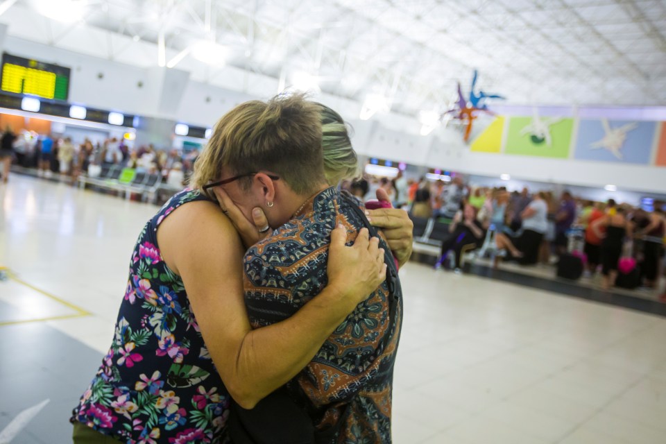 Pals comfort each other as they wait to get repatriated from Las Palmas to the UK