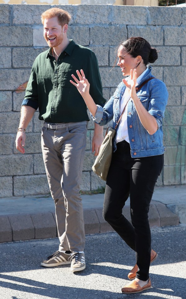  Meghan waves as she walks next to husband Prince Harry this morning