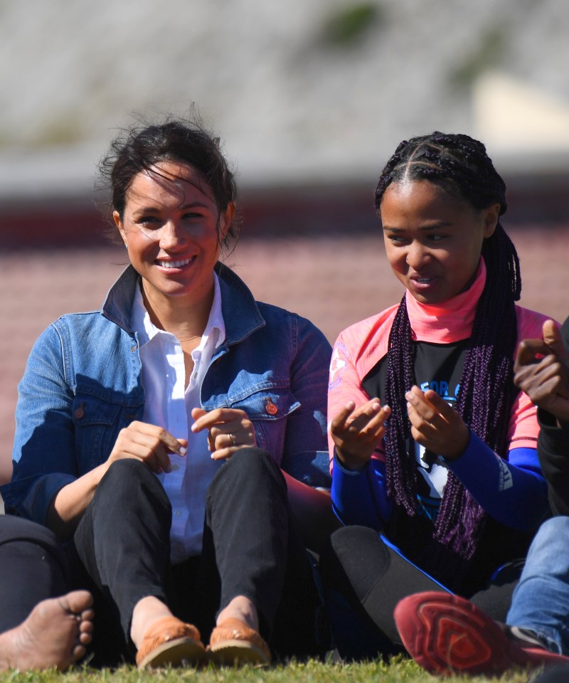  Meghan Markle laughs as she joins in one of the activities