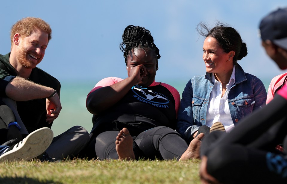  Meghan and Harry chat with one of the young surfers