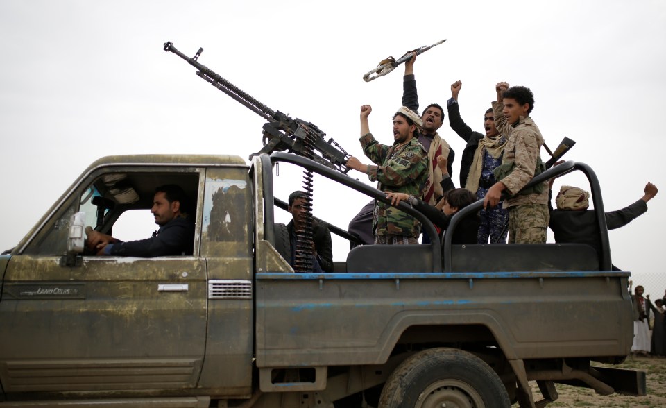  Houthi rebel fighters pictured last month chanting slogans as they take off to a battlefront