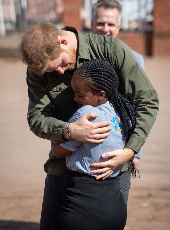 Prince Harry hugs Tlotlo Moilwa from Botswana, who is HIV positive