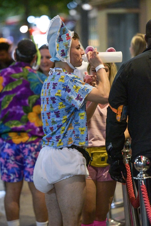  A lad dressed as a baby drinks from a bottle