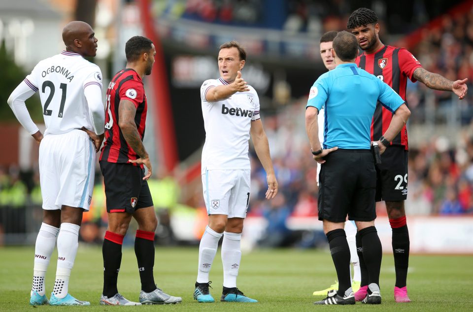 Referee Stuart Attwell deals with players from Bournemouth and West Ham as Andrew Madley checks the goal