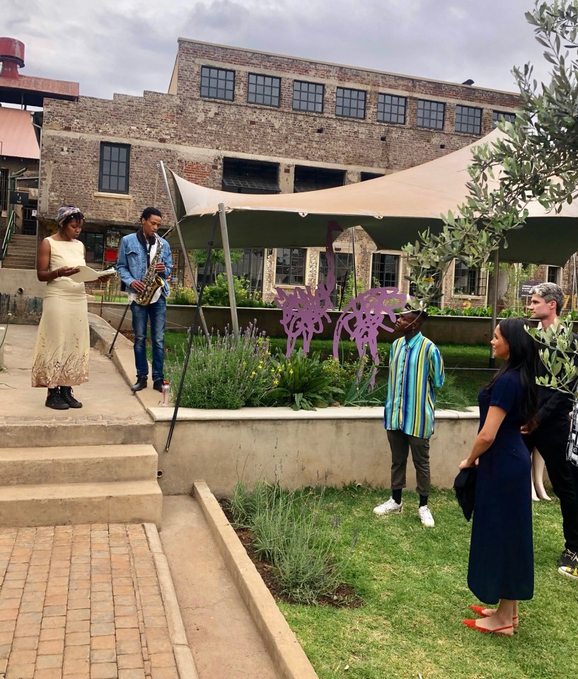  Meghan stopped to listen as a woman read from a book and a man accompanied her on a saxophone