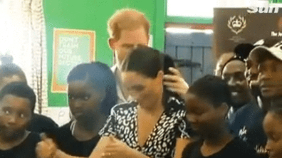 The Duke of Sussex was spotted “lovingly” smoothing his wife’s ponytail during a trip to the township of Nyanga