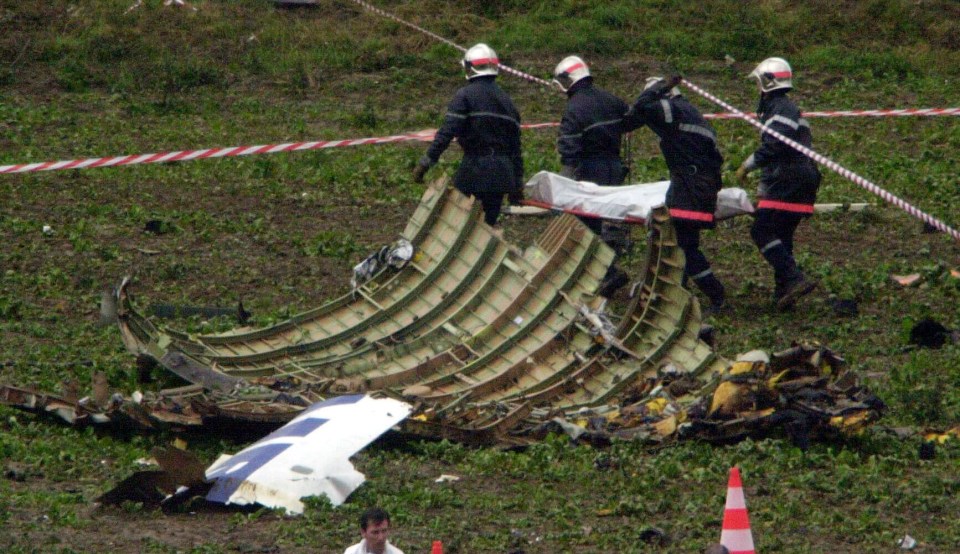  French emergency services removing the remains of one of the 113 people killed in the crash from the site