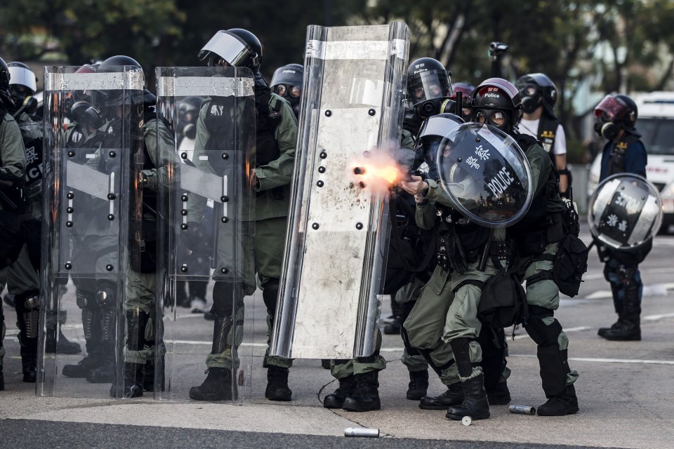 Riot police fire projectiles against protesters in the Sha Tin district of Hong Kong on October 1