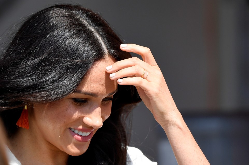  The duchess adjusted her hair in the South African sun as thrilled fans looked on