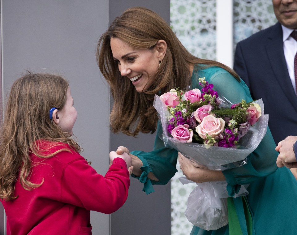  Kate beams as she is given flowers from a young girl