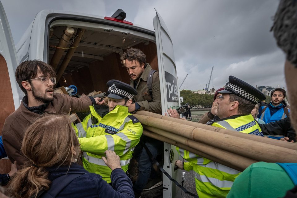  Protesters struggle to prevent their equipment being confiscated by police from a van during the occupation of Westminster Bridge