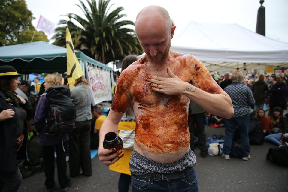  A climate change activist smears Marmite on his body as he demonstrates on Lambeth Bridge in central London