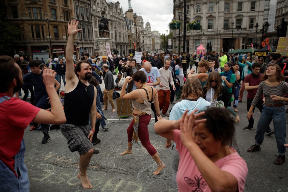  Extinction Rebellion dance to music as they block a street at the bottom of Trafalgar Square