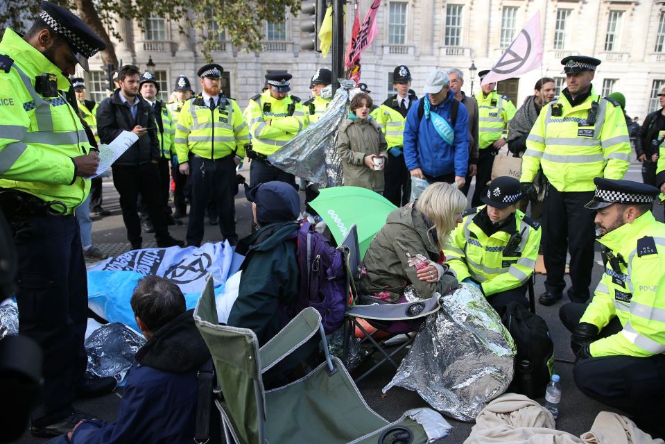  Police officers surround activists on Whitehall during the third day of demonstrations by the Extinction Rebellion climate change group