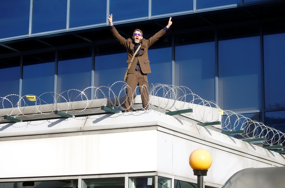  The man climbed onto the roof outside the entrance to the cheers of fellow activists