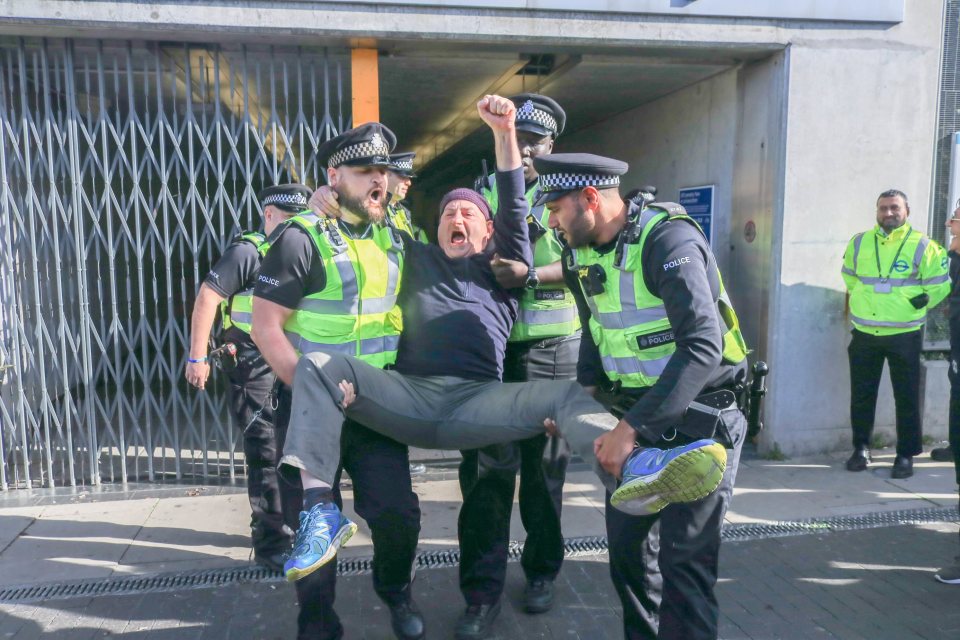  Police lead away a protester from the airport