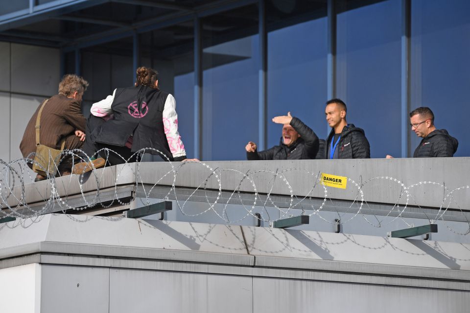  Negotiators try to persuade the activists to come down from the roof