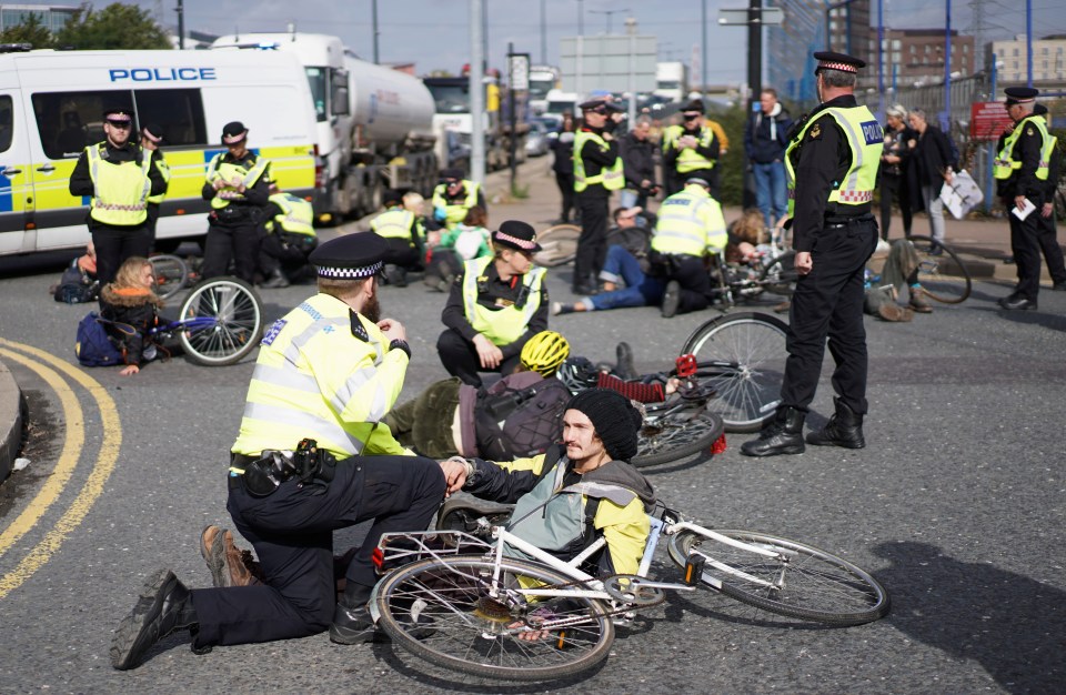  Extinction Rebellion protesters with bikes block a roundabout near City Airport