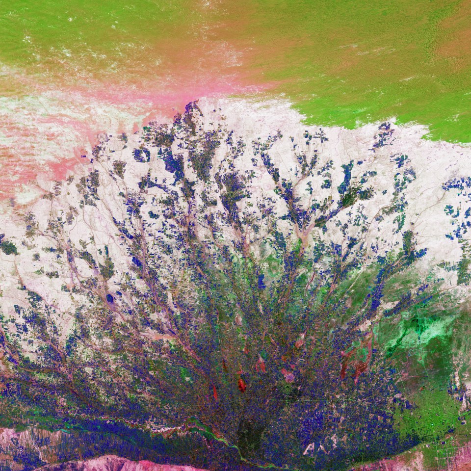 Water from the Balkh River fans out into an agricultural area toward an arid region in northern Afghanistan, near the border with Uzbekistan and Turkmenistan. Part of an ancient region called Bactria, extensive irrigation produces melons, almonds, apricots, and grains. Mazar-e Sharif is the urban area that dominates the lower right corner of the image.