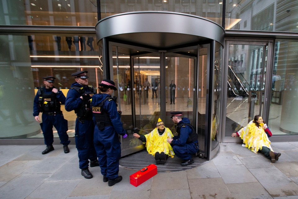 Protesters dressed as yellow canaries glued themselves to the entrance of the Walkie Talkie building