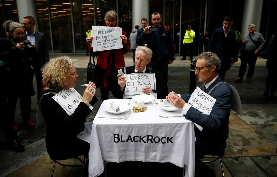 Protesters eat fake money outside the BlackRock office in the City of London