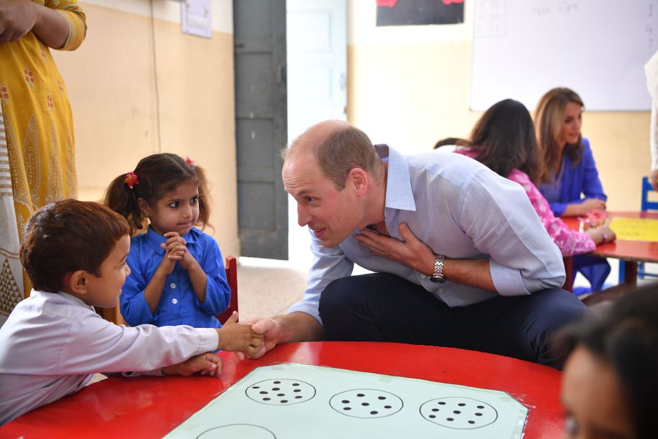  William shook hands with young pupils, but one student didn't look sure