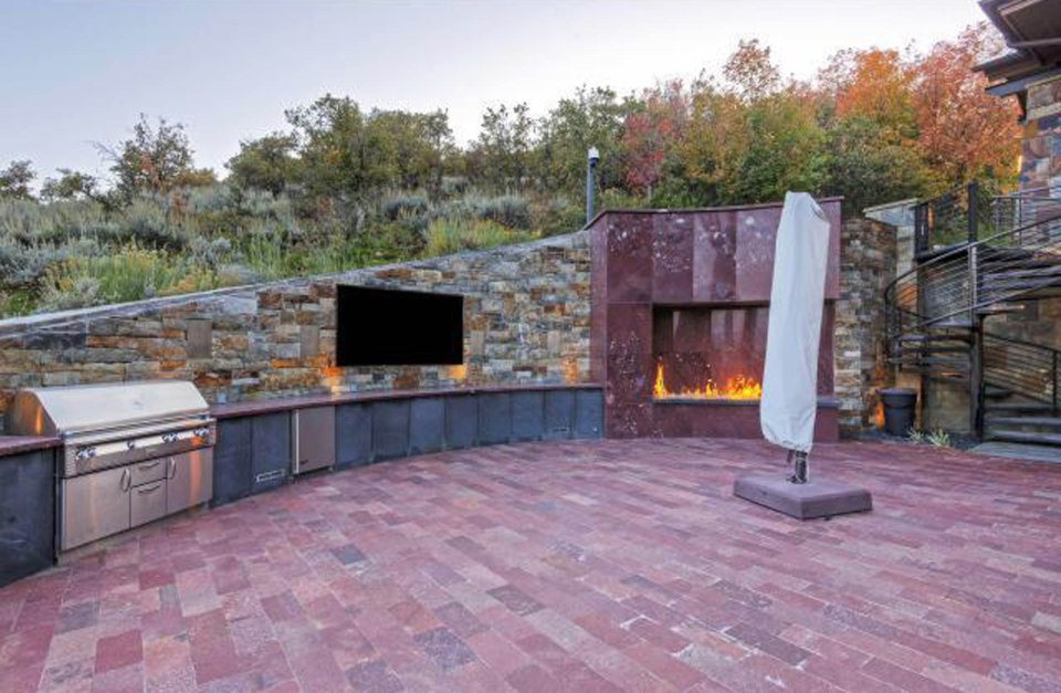  The outside of the home is spacious, featuring BBQ pits and a swimming pool