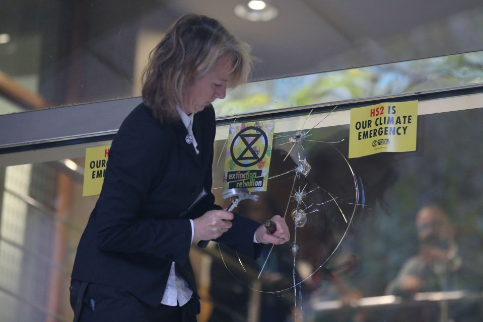 Gail Bradbrook smashes a window at the Department of Transport on Tuesday morning