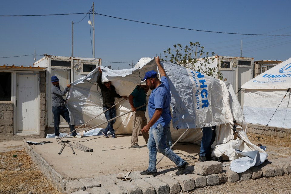  Workers set a tent in preparation to receive a few hundred Syrian refugees who have been newly displaced by the Turkish military operation in northeastern Syria