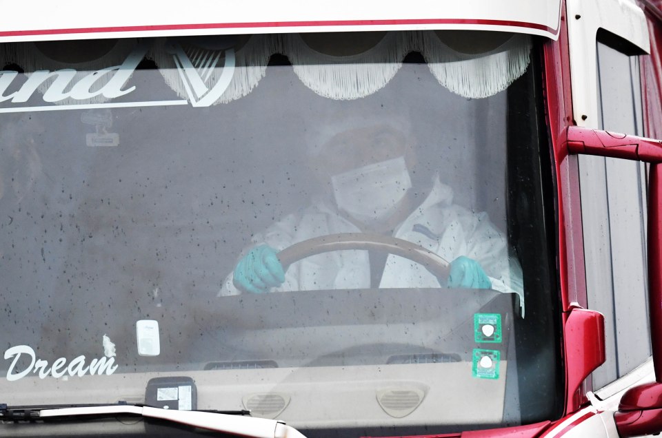  A forensic officer drives away the lorry, which will be brought to Tilbury Docks